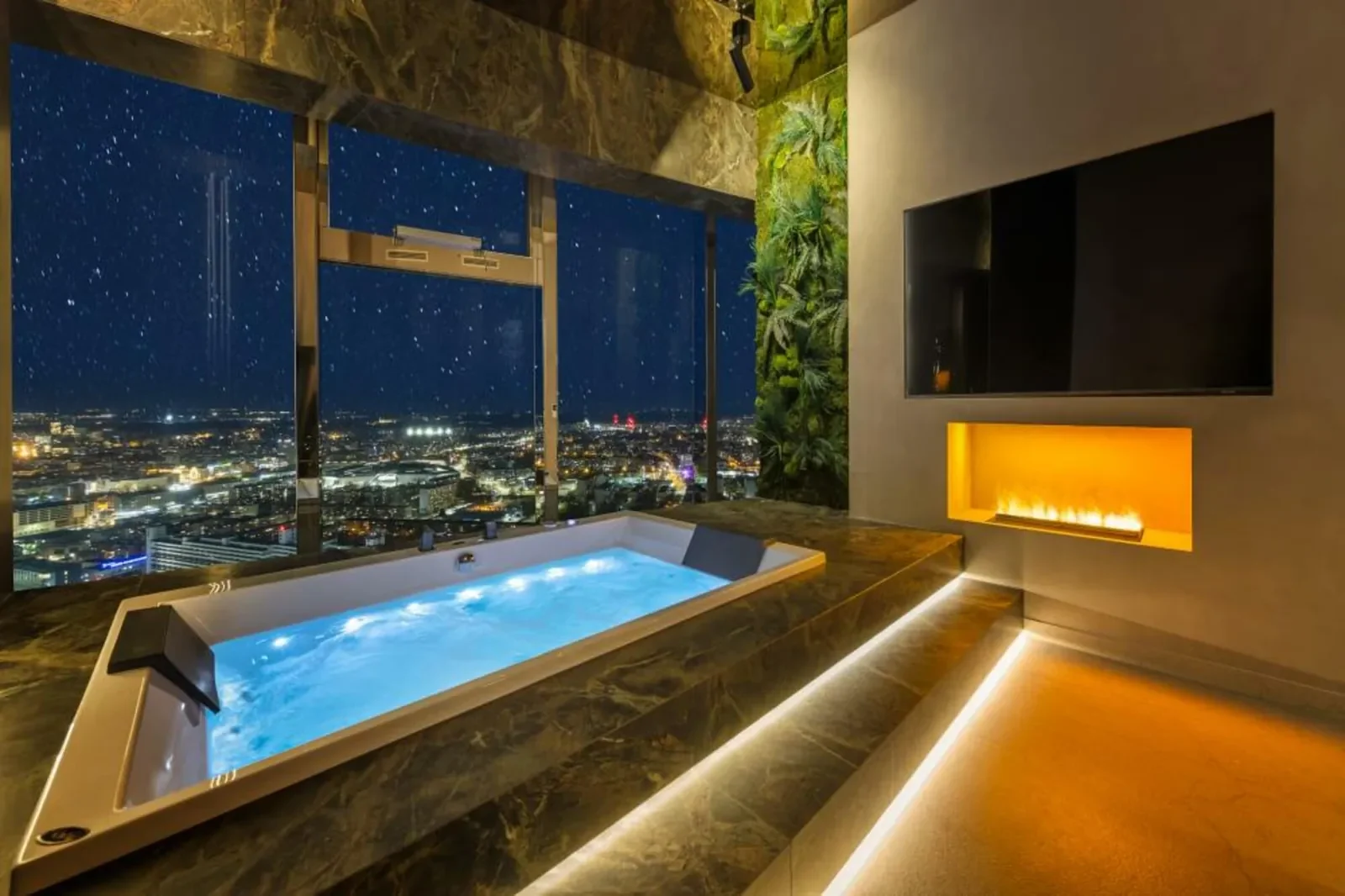 Apartament Madera: jacuzzi przy oknie z widokiem na nocny Wrocław
